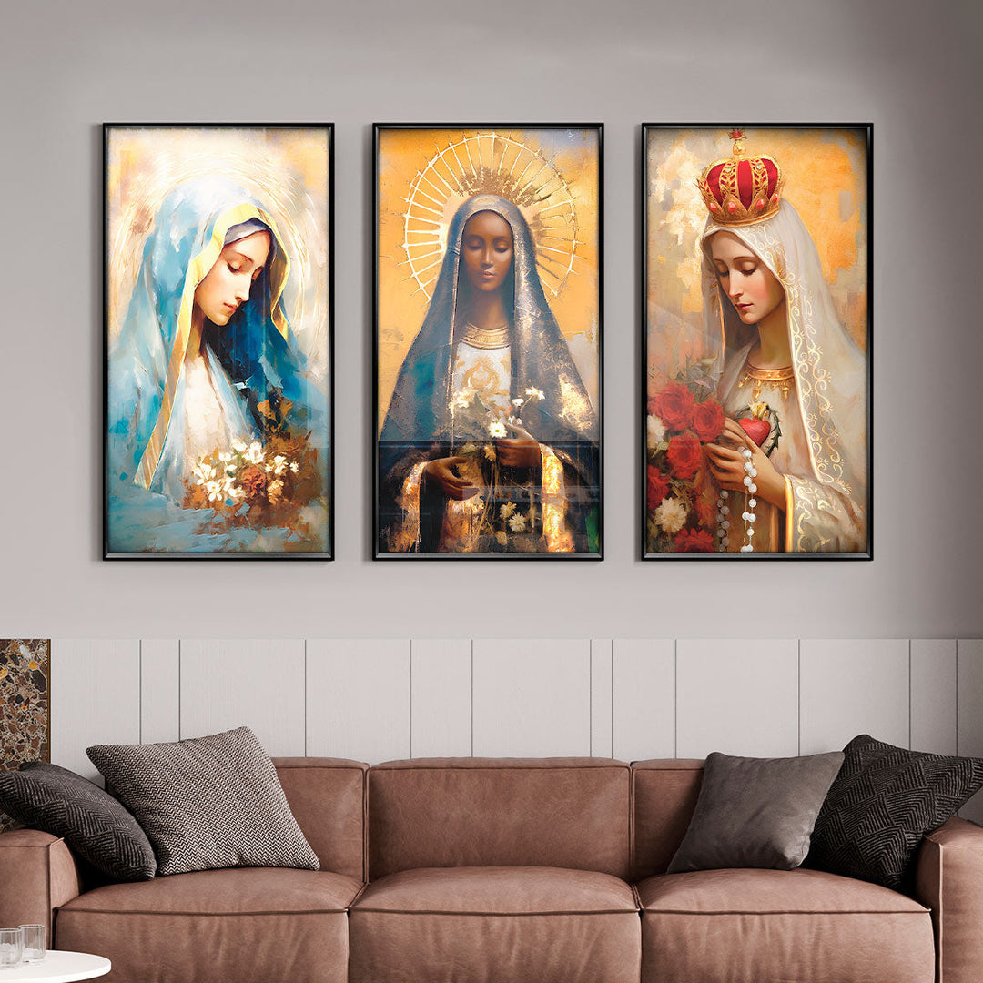 A set of three framed art prints depicting Our Lady of Grace, Our Lady of Fatima, and Our Lady of Aparecida, displayed above a sofa.