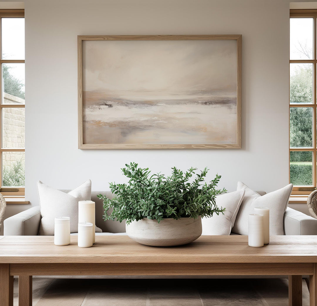 Framed beige and grey abstract landscape displayed on a modern neutral living room wall